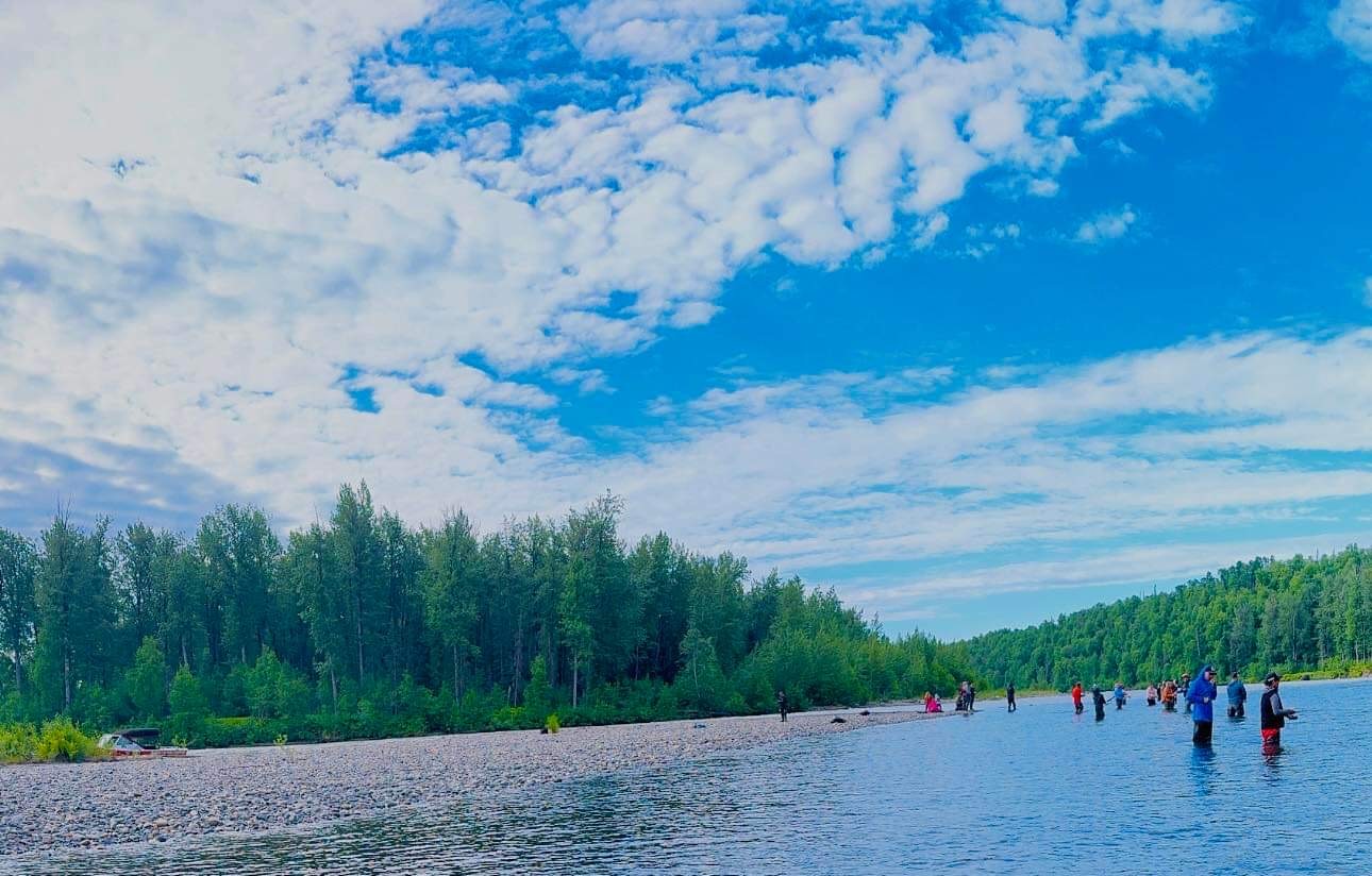 17483541384122-fish8-1 a group of people standing next to a lake