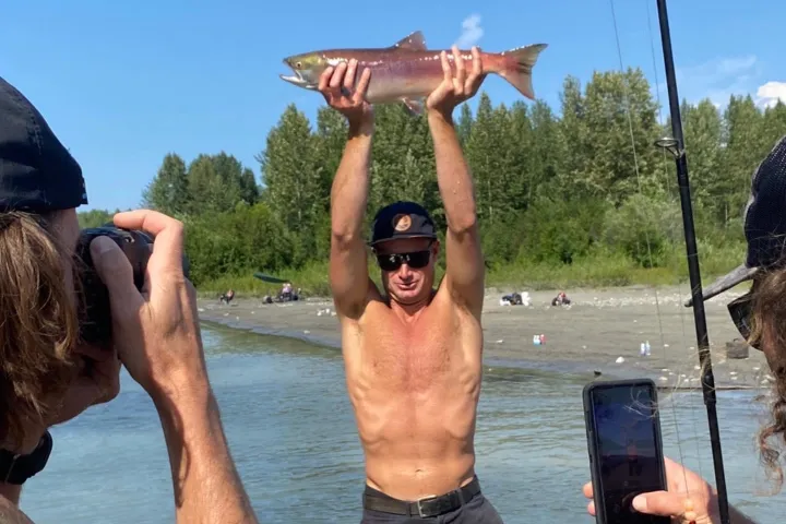 a man holding a fish in the water