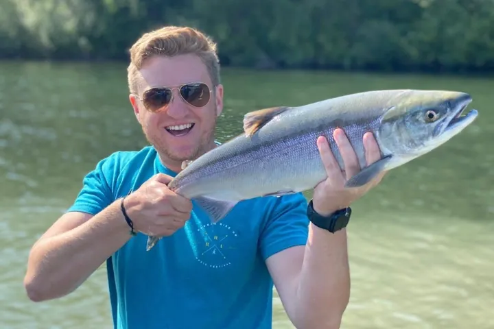a man holding a fish in the water