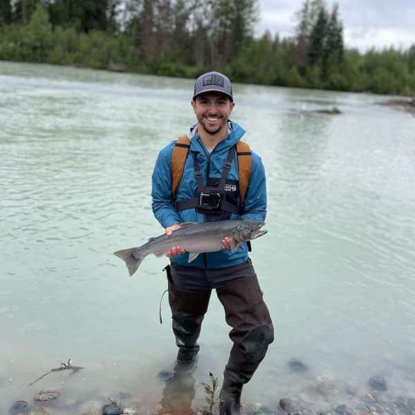 a man standing next to a body of water