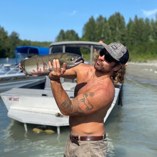 a man holding a fish in the water