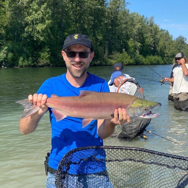 a man holding a fish swimming under water
