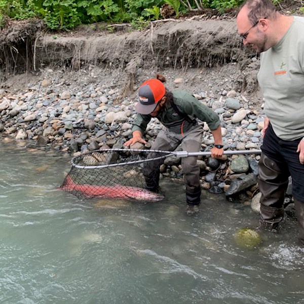 a man standing next to a river