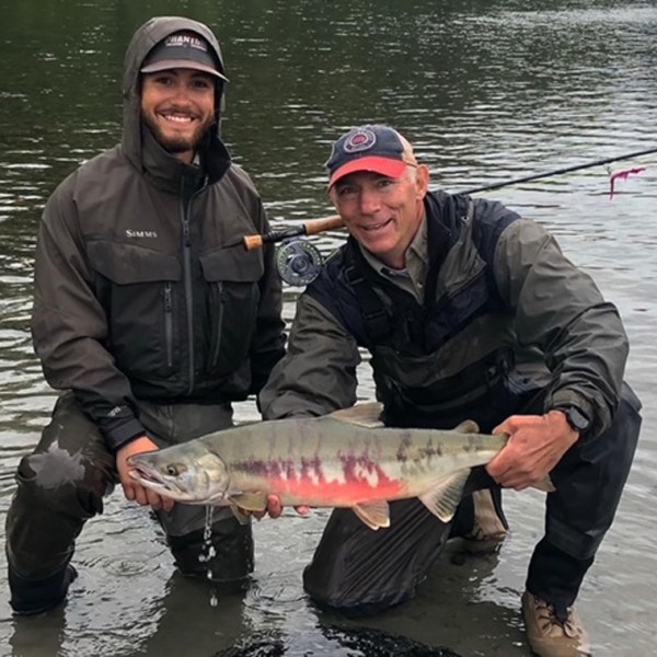 a man holding a fish in the water