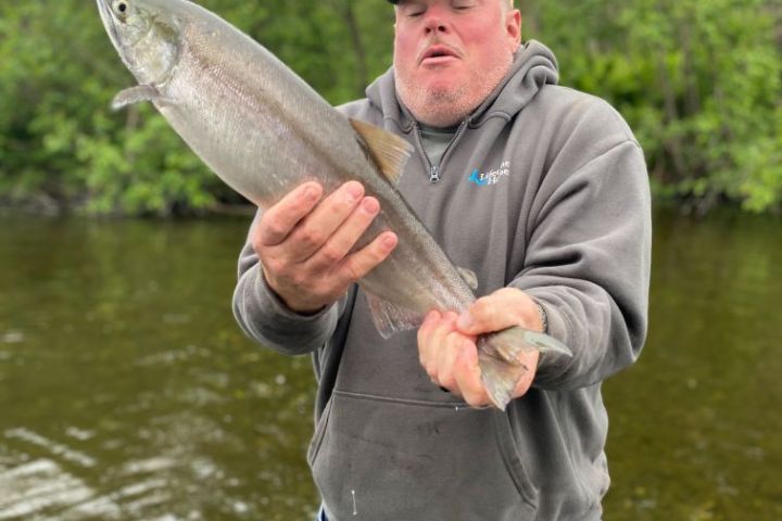 a man standing next to a body of water