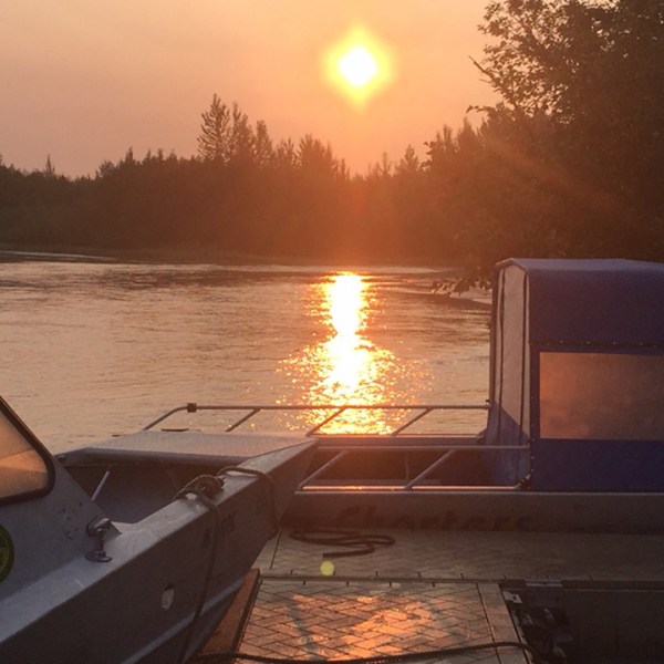 a boat that is sitting in front of a sunset