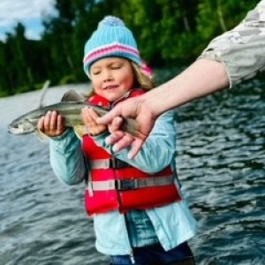 a little boy standing next to a body of water