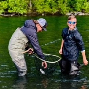 a man standing next to a body of water