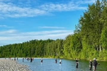 a group of people standing next to a body of water