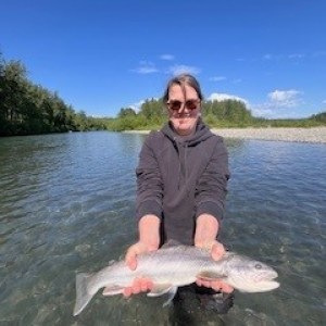 a man holding a fish in the water