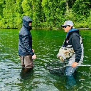 a man standing next to a river