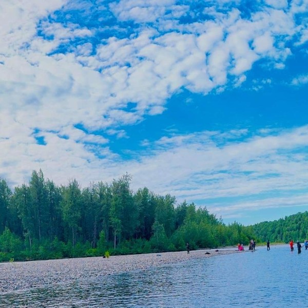 a group of people standing next to a lake