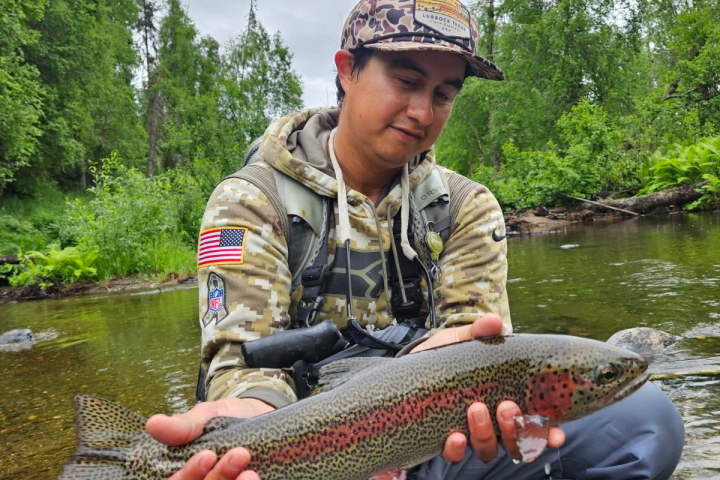 a man holding a fish in the water